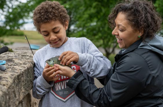 Mother and son holding a fish while fishing
